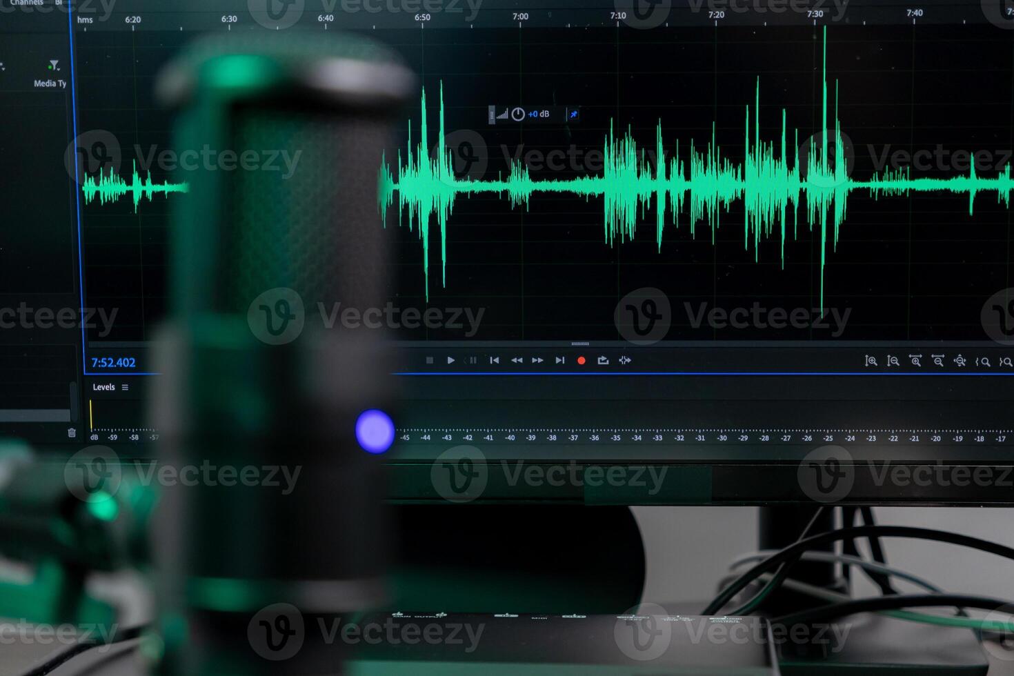 Professional desktop microphone with vibrant green audio waveform on monitor, illustrating sound engineering, podcasting, and digital content creation photo