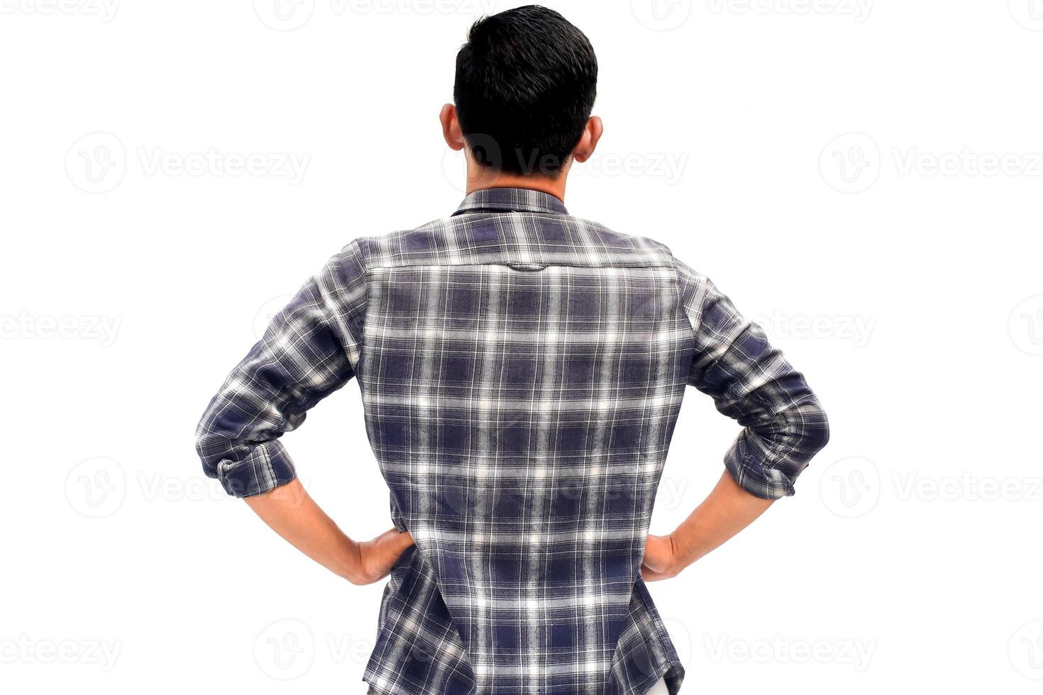 Back view of a young man in a plaid shirt against a plain white background, thoughtful posture photo