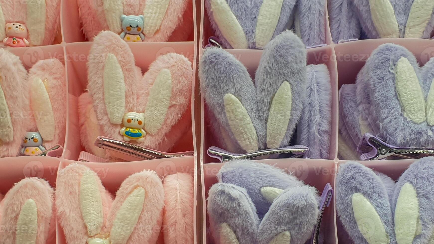 Display of Kawaii Bunny Ear Hair Clips in Pastel Pink and Lilac Purple in Compartmentalized Boxes photo