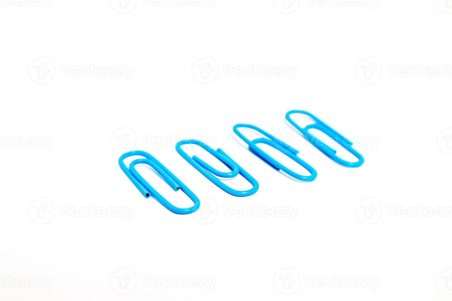 A group of blue paper clips on a white background, used for holding paper photo