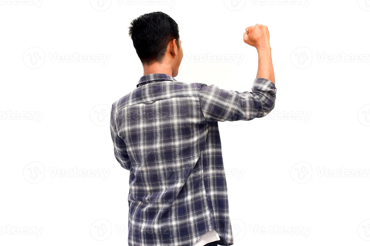 Rear view of an Asian man in a plaid shirt with raised arm, expressing success against white background photo
