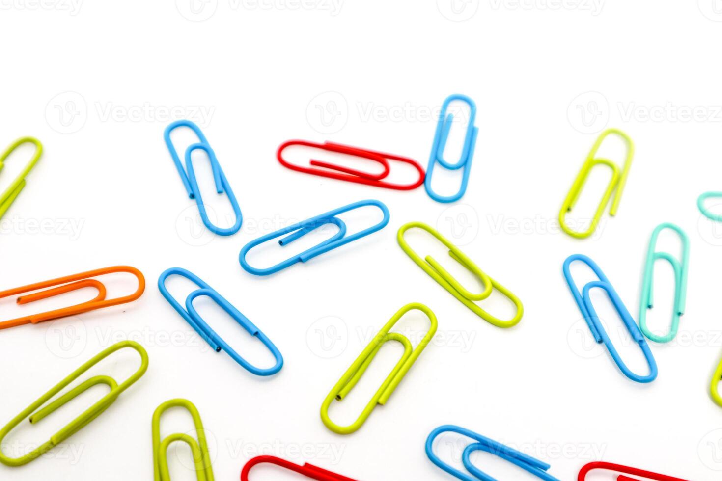 Colorful Paper Clips Scattered on a White Background, Perfect for Office or School Supplies photo