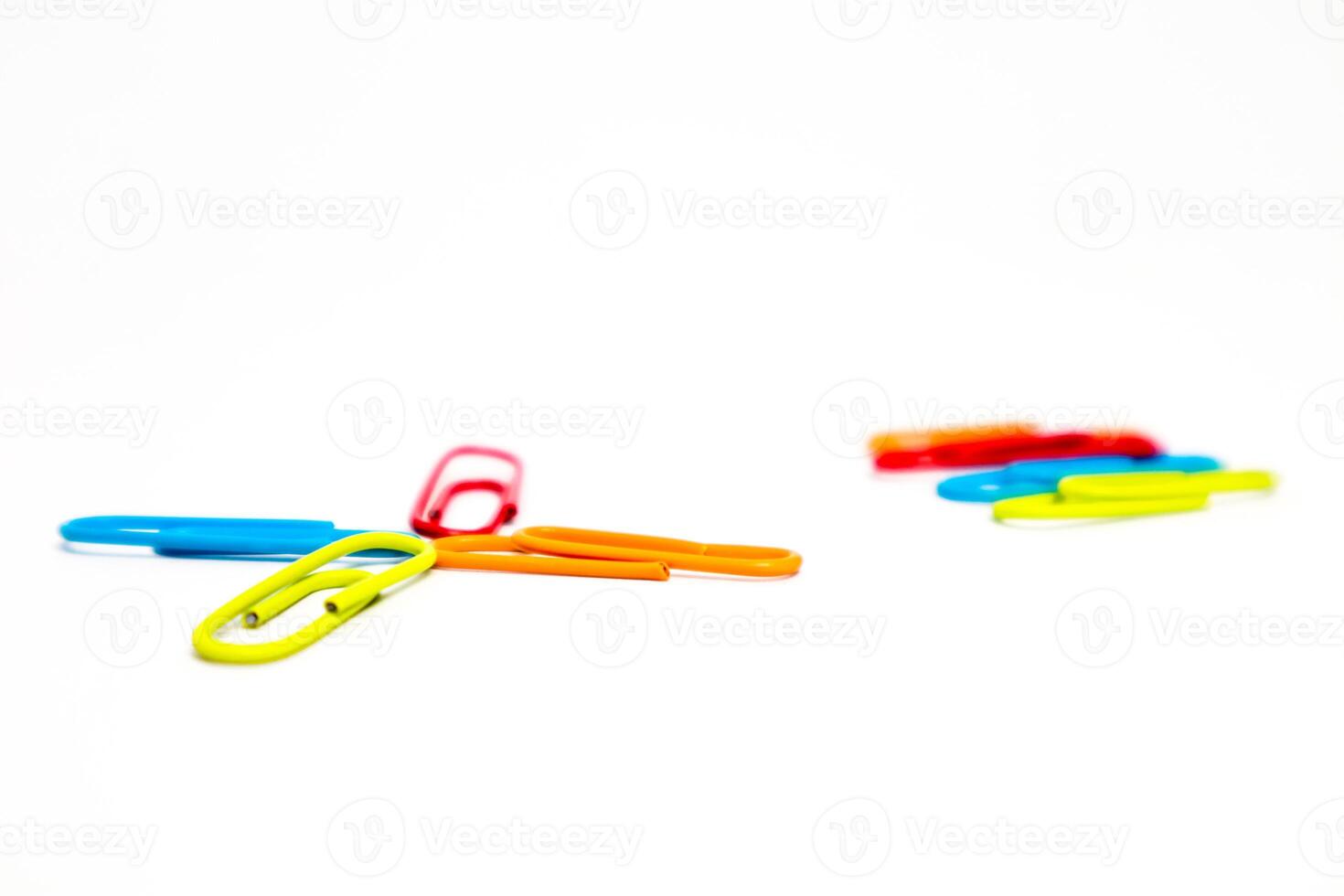 Colorful Paper Clips on a White Background with Minimalist Composition and Studio Lighting photo
