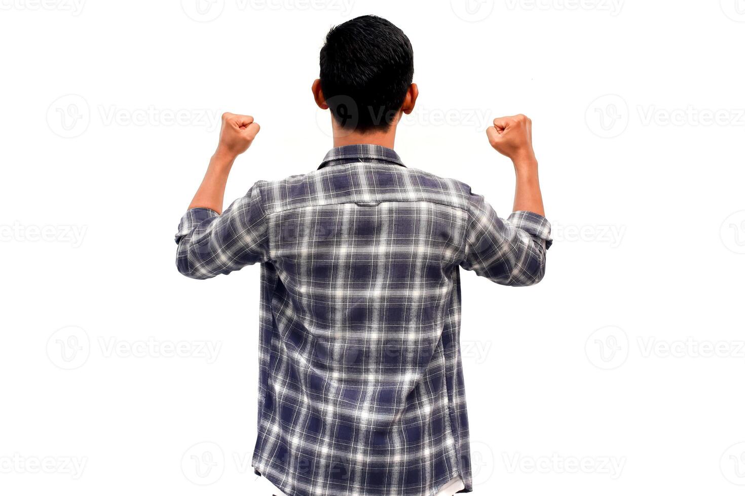 Rear view of a celebrating Asian man in a plaid shirt with fists raised in success on a white background photo