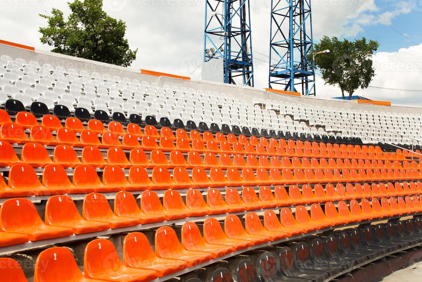 a section of a stadium with rows of plastic seats. Ideal for use in articles about sports venues, event planning, or urban infrastructure photo