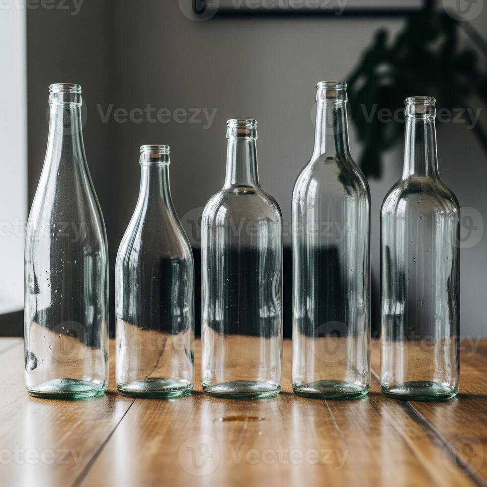 Five empty glass bottles on a wooden table photo
