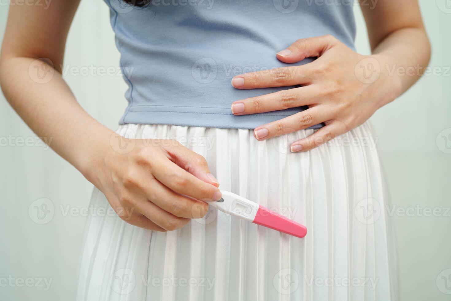 Asian holding pregnancy test for female of ovulation day, fetus, maternity, childbirth, birth control. photo