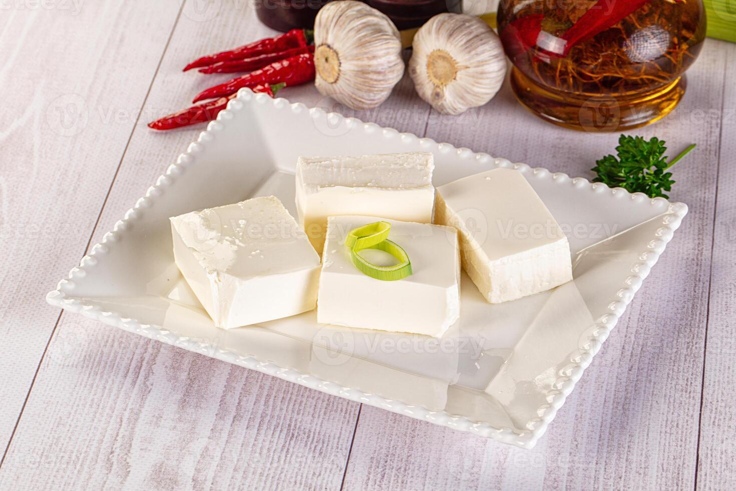 A white plate topped with cubes of cheese and garlic photo