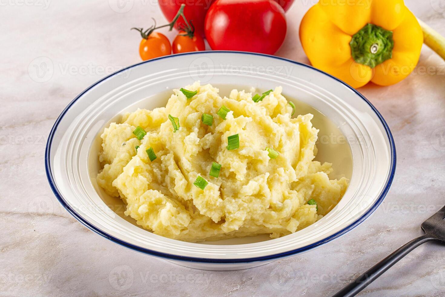 A bowl of mashed potatoes with vegetables photo