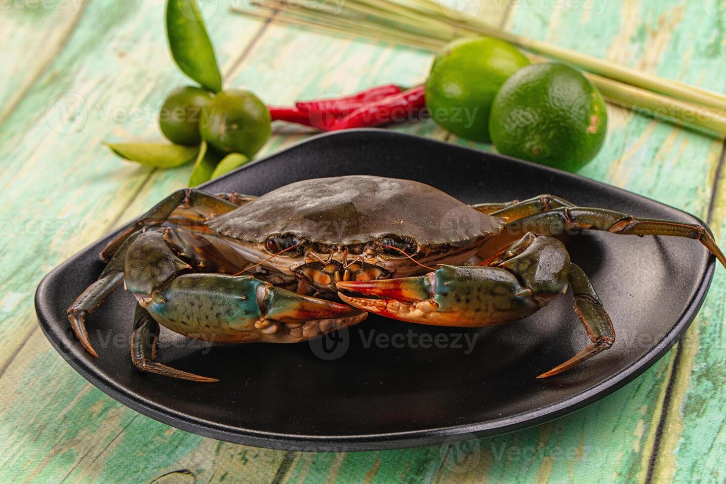 A crab on a black plate with lime and chili photo