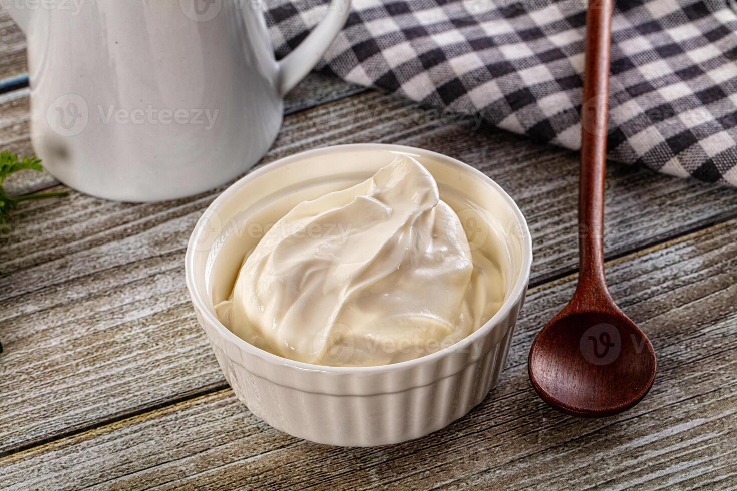 Yogurt in a bowl with a wooden spoon photo