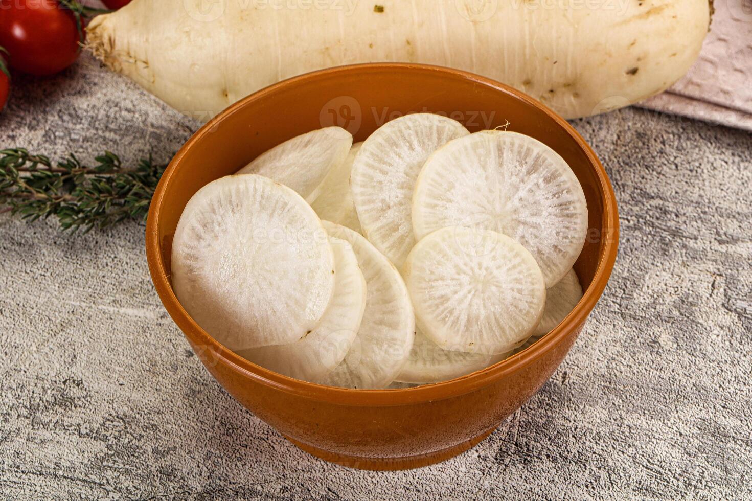 A bowl of sliced white radishes sitting on a table photo