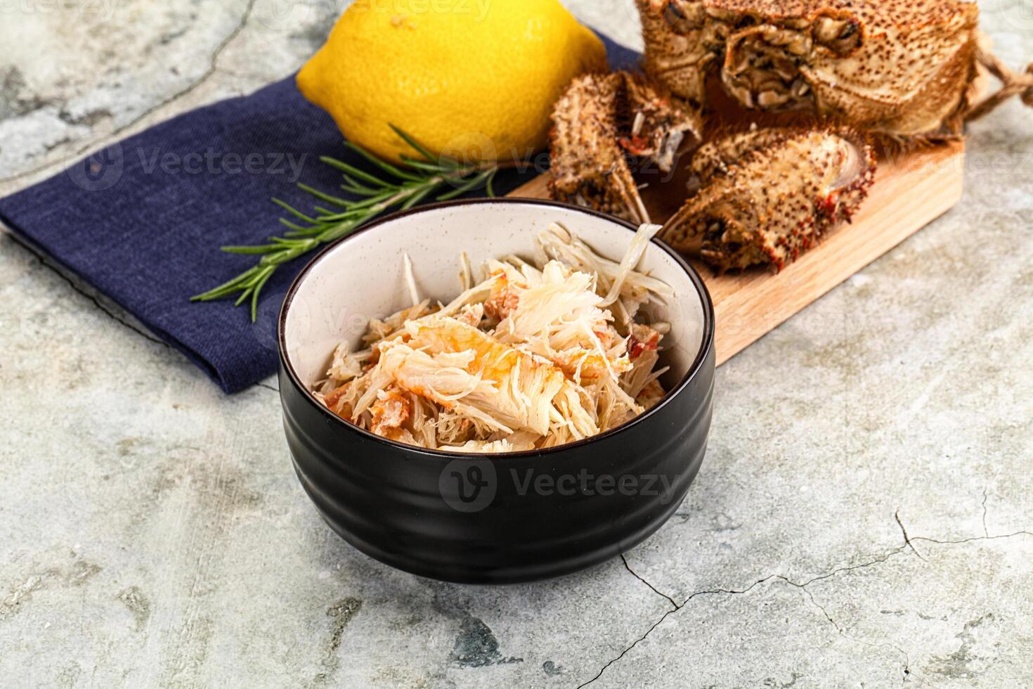 A bowl of food with crab meat and lemon photo