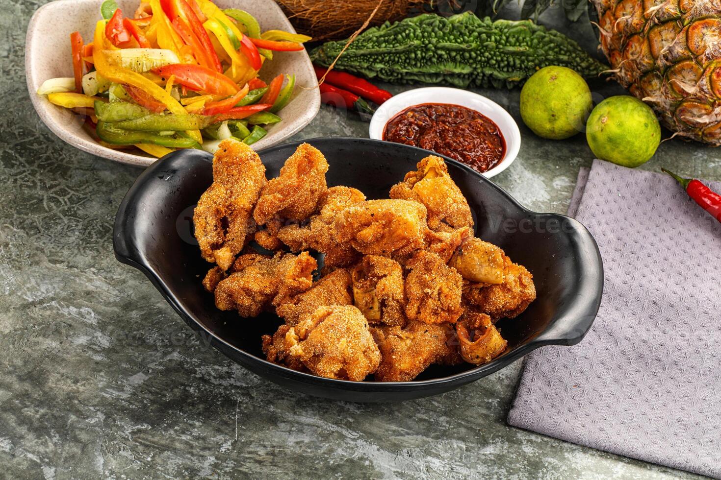 A bowl of fried chicken, a bowl of vegetables and a pineapple photo