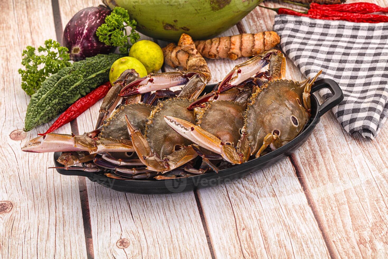 A bunch of crabs sitting on a plate with other vegetables photo