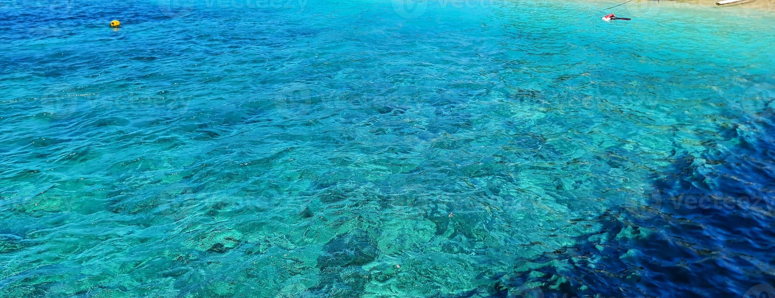Crystal Clear Turquoise Sea Water with Coral Reef and Distant Person photo