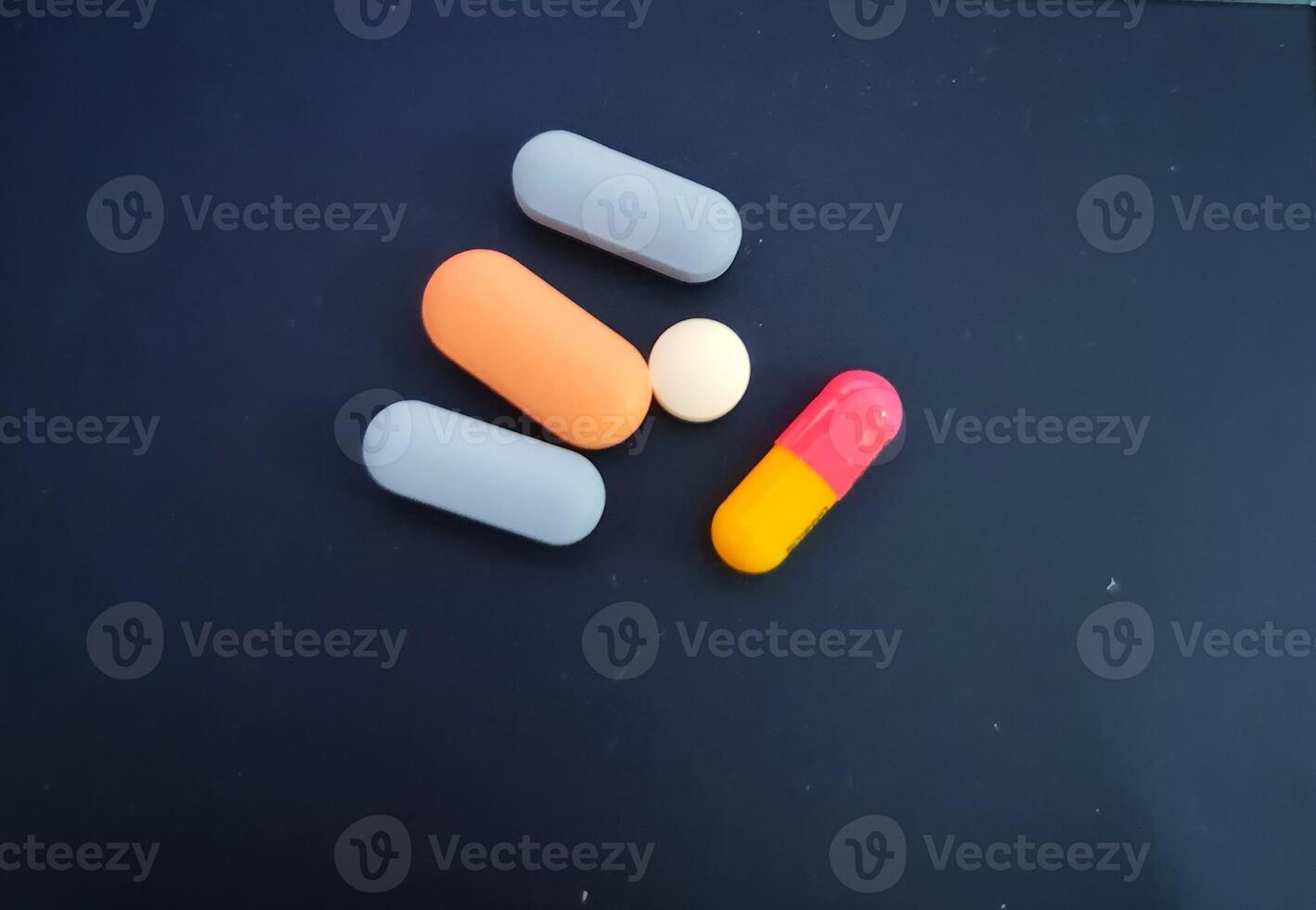 Colorful Medication Pills Assorted on Dark Surface photo