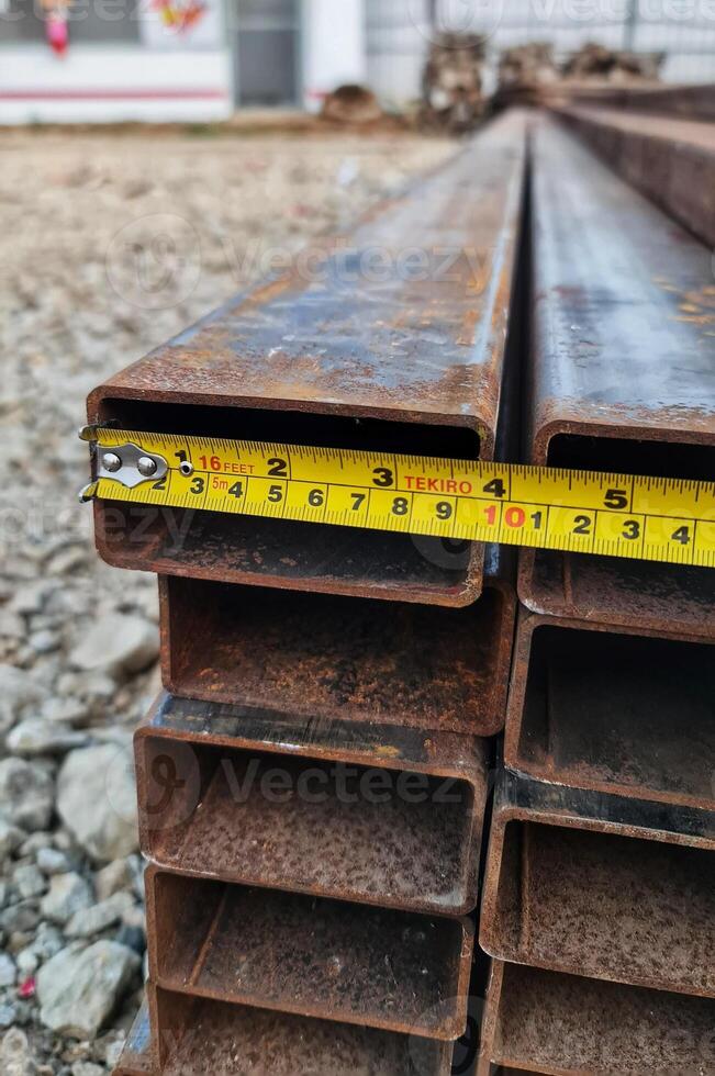 Measuring Metal Rectangular Tubes with Tape Measure for Construction photo