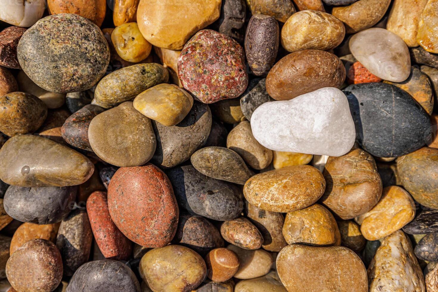Rounded colorful stones top view relaxing texture organic pebble pattern tranquil beach surface natural calm mood earthy tones meditation scenery outdoor detail peaceful nature composition photo