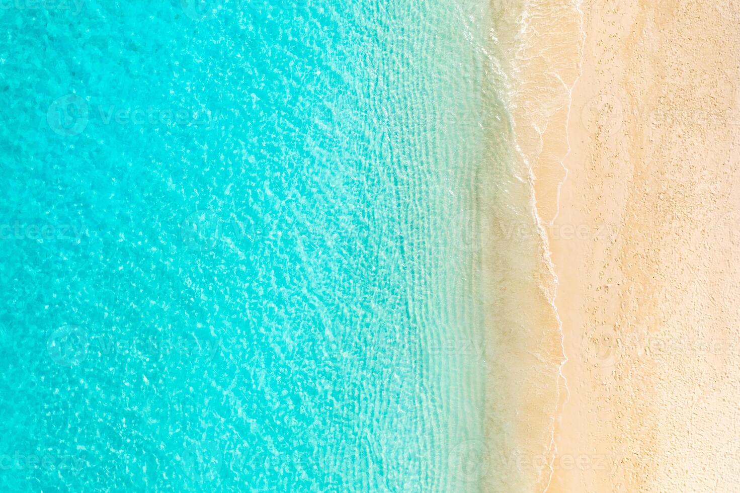 Aerial top view of empty Caribbean beach with yellow sand and clear turquoise water, peaceful tropical shoreline for summer vacation, nature background and travel destination photo
