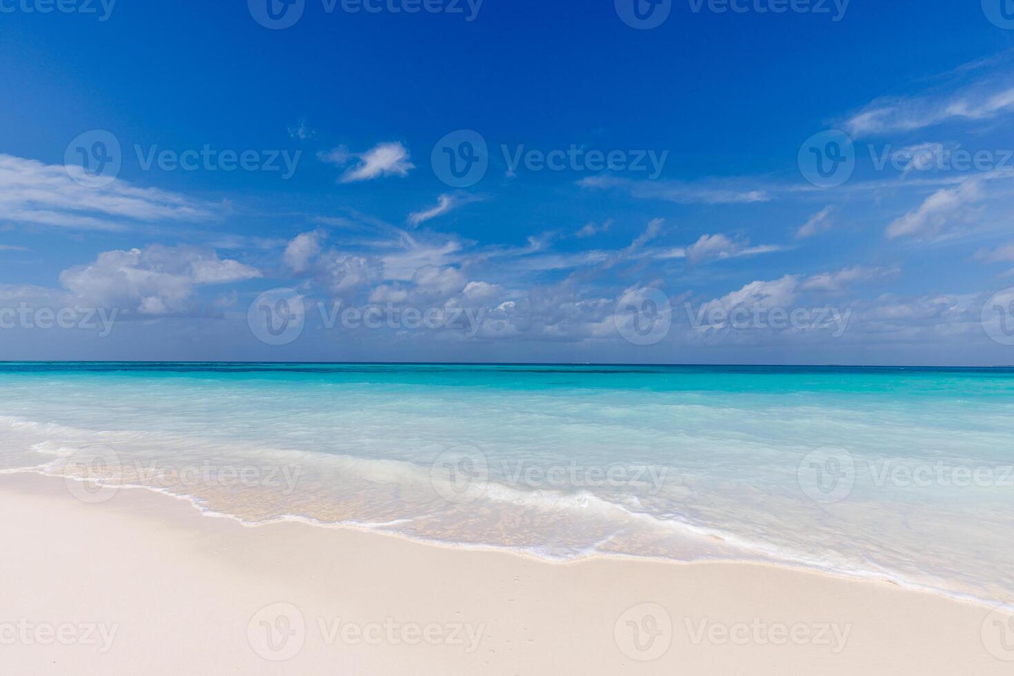 Amazing sunny beachfront with soft sand and clear sea under a bright blue sky, offering a tranquil summer vacation scene with a minimal nature background perfect for relaxation and peaceful moments photo