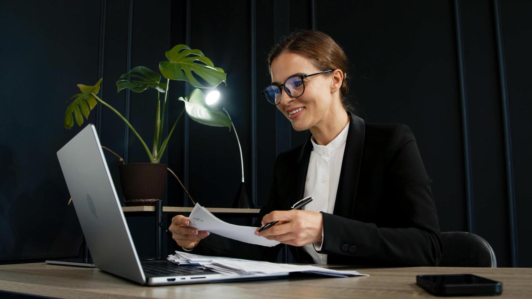 A trendy young woman using a laptop in a sleek modern office, perfect for themes of business, work-life balance, and contemporary productivity photo