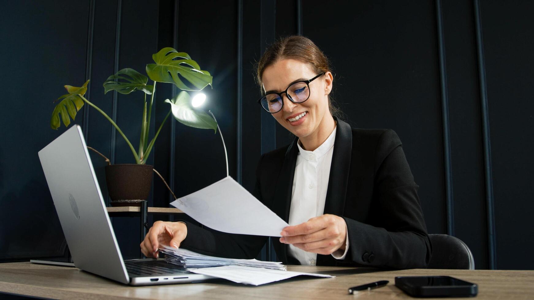 Woman working in a modern office and reviewing documents and bills. Concept of professional activity, office efficiency and financial management. photo
