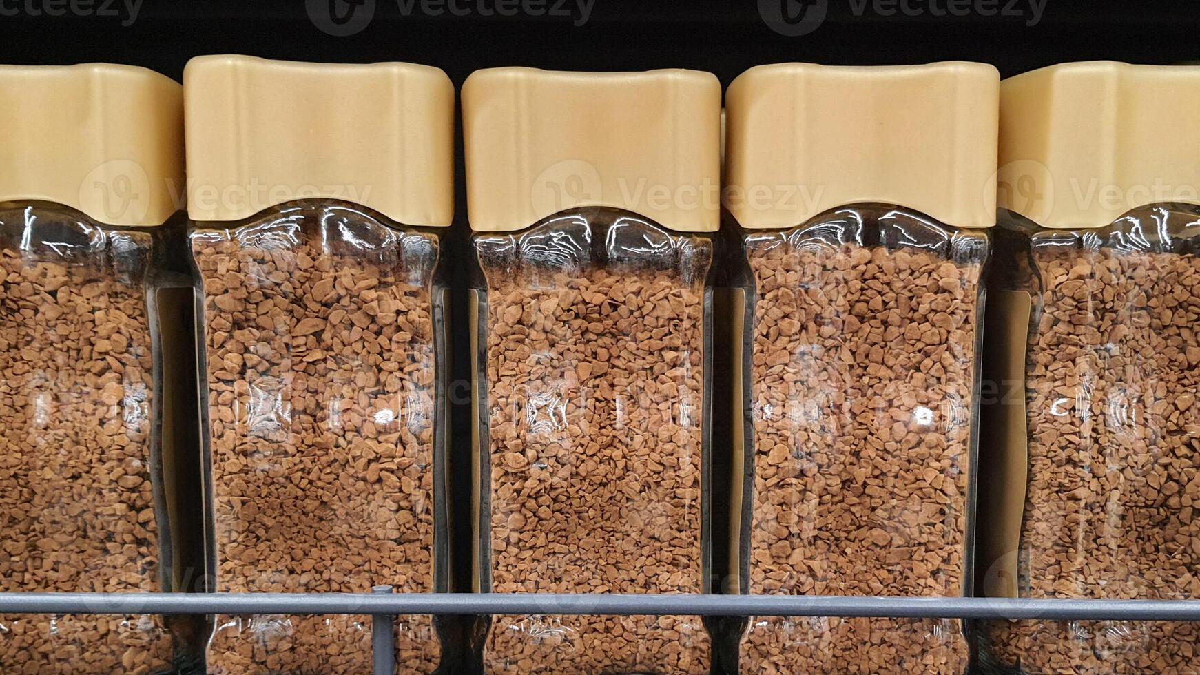 Glass jars of instant coffee filling a supermarket shelf photo