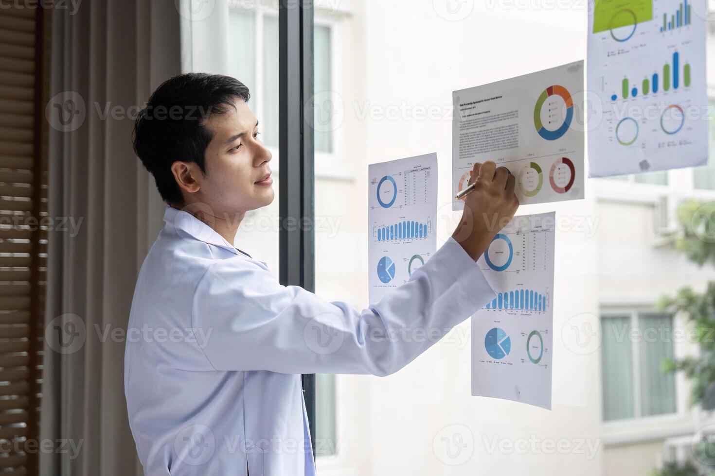 Doctor writing insights from data analysis on report at hospital photo