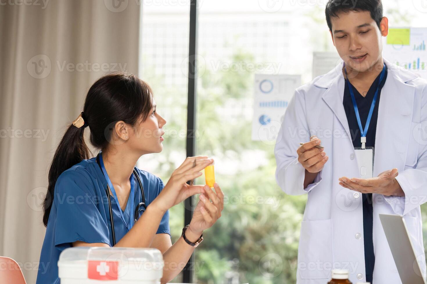 Doctor explaining medication instructions to a nurse photo
