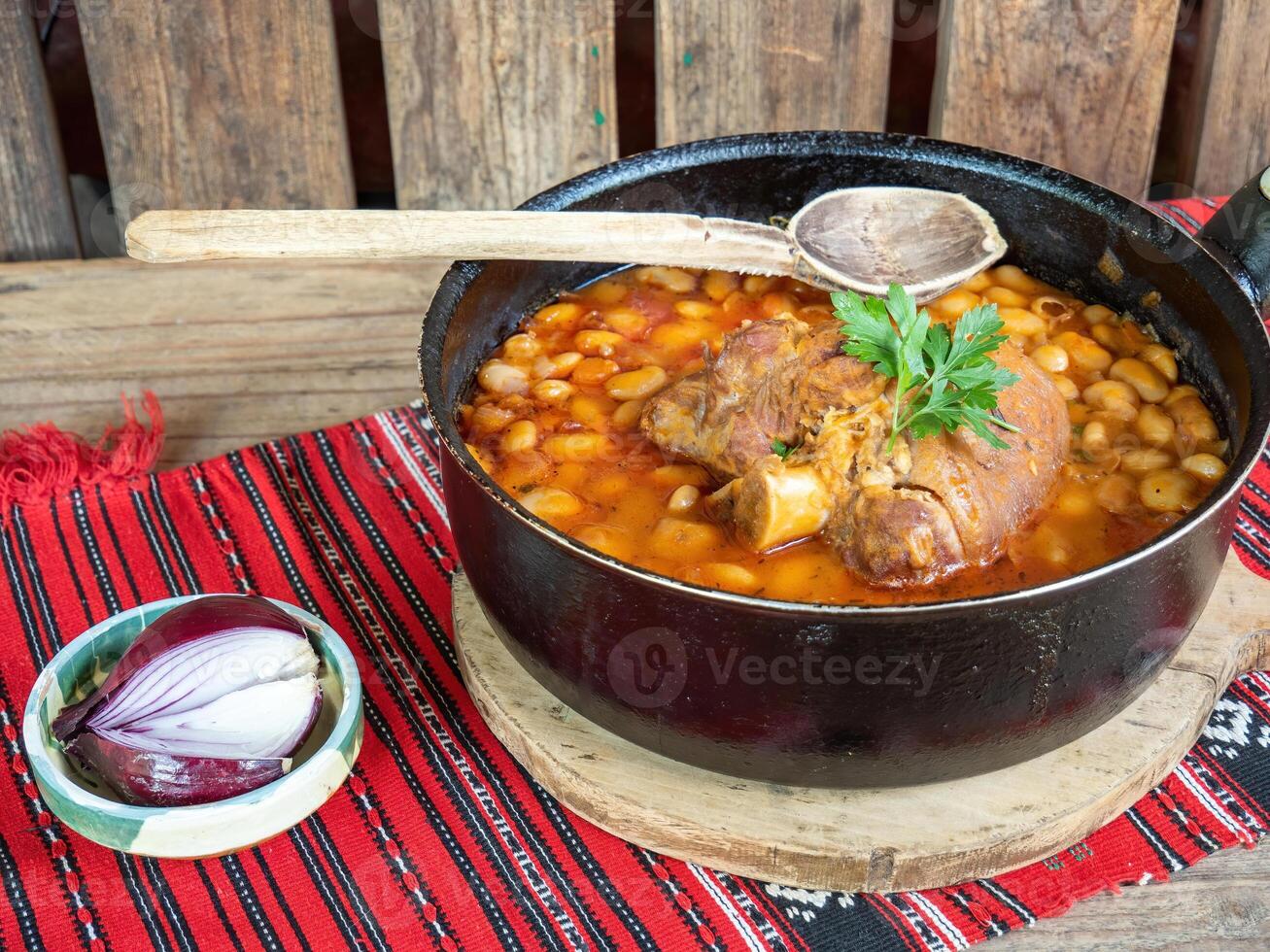 A pot of beans and meat on a table photo