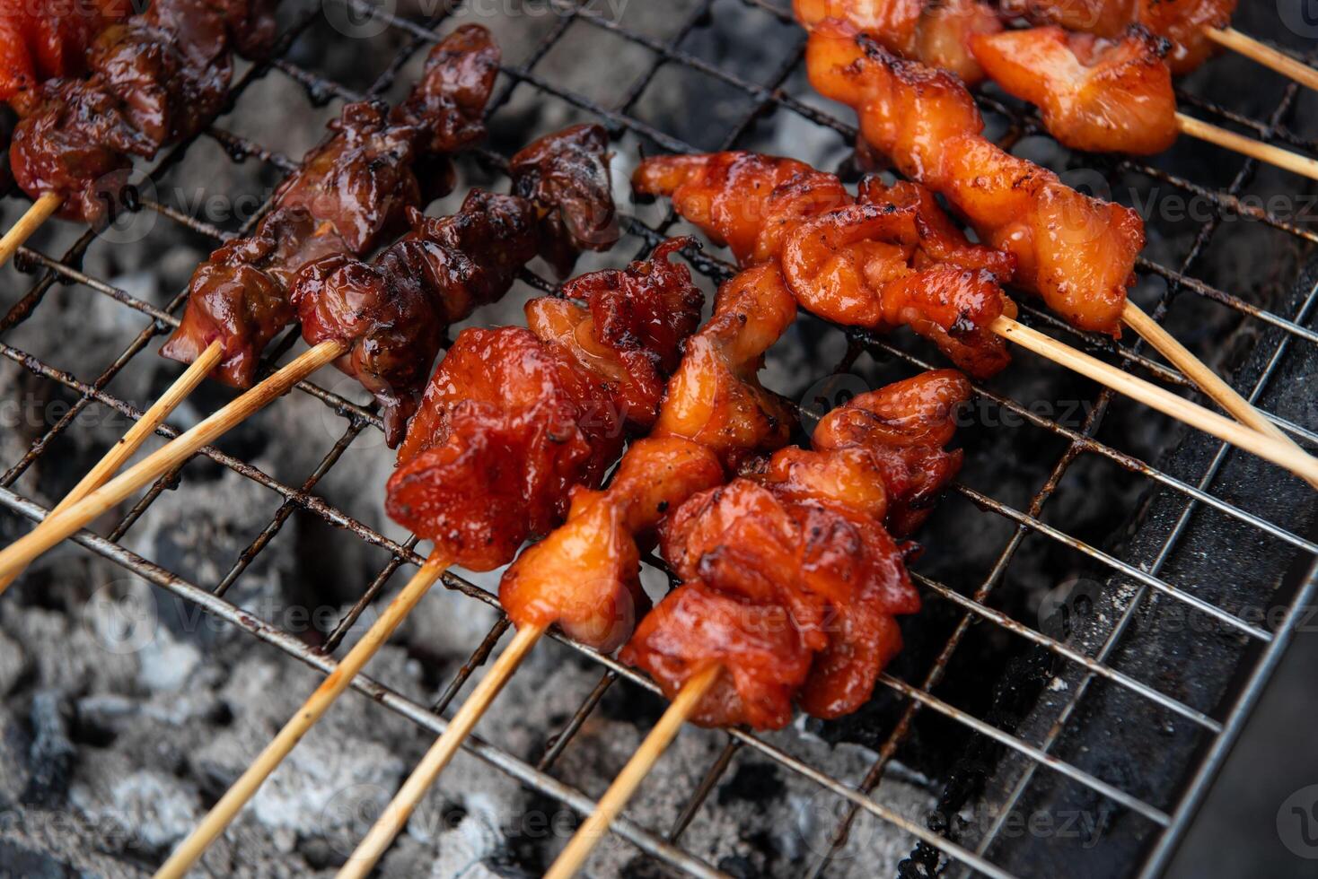 A grill with skewers of meat on it photo
