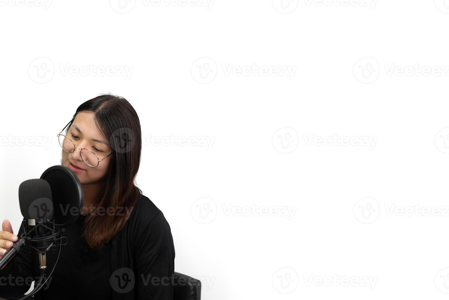 A woman in a recording studio singing into a microphone photo