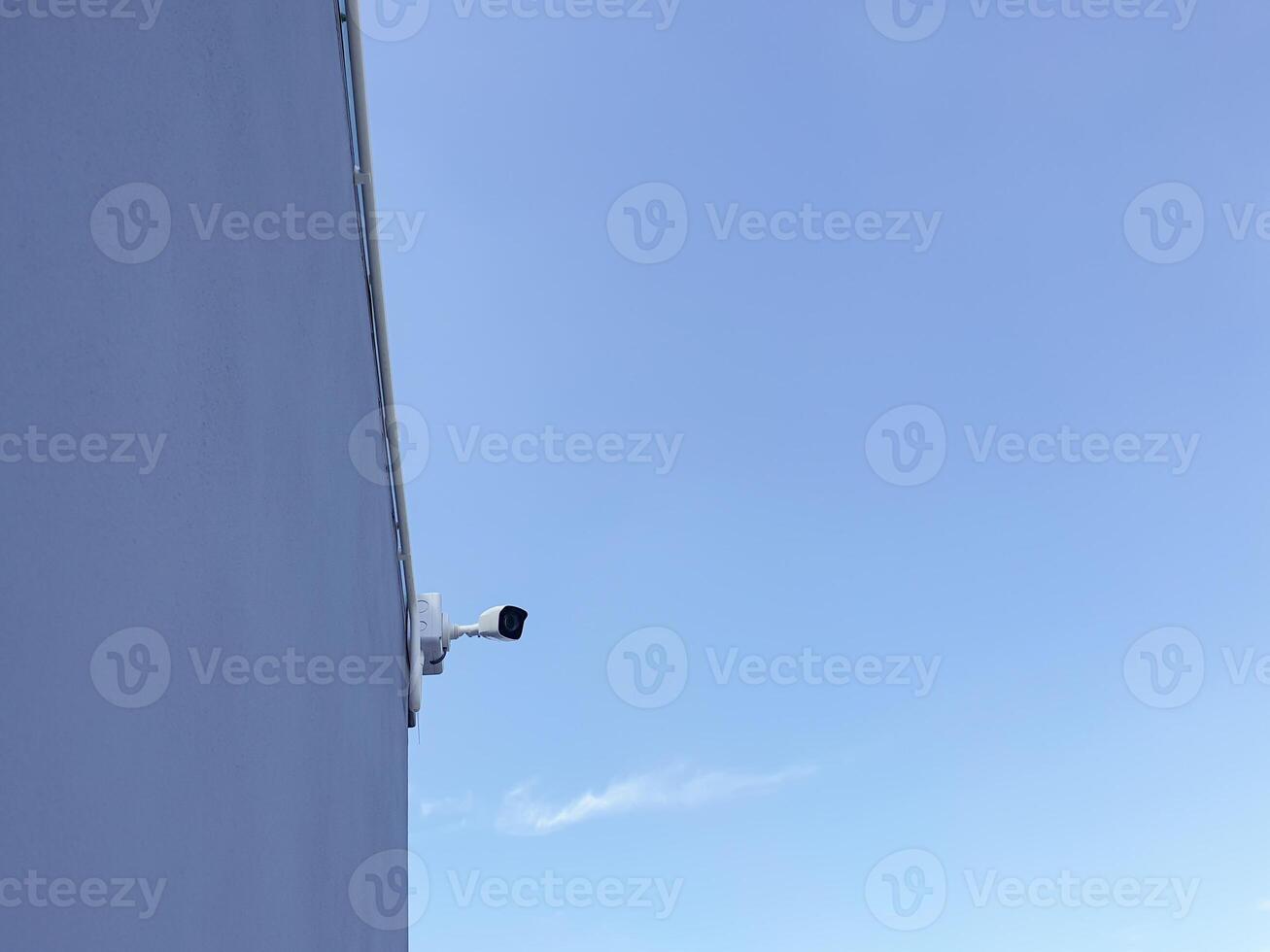 A camera is mounted on the side of a building photo