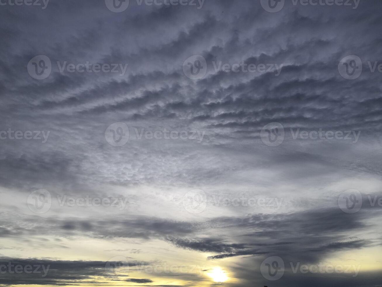 A sunset with clouds and a boat in the distance photo