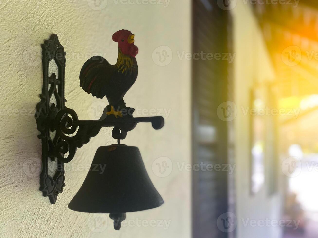 A rooster on a bell on a wall photo