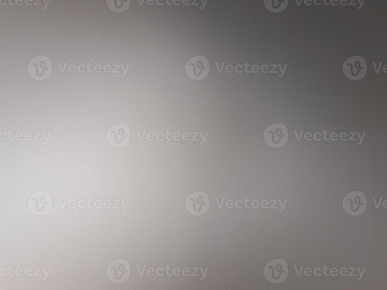 A man is standing in front of a gray wall photo