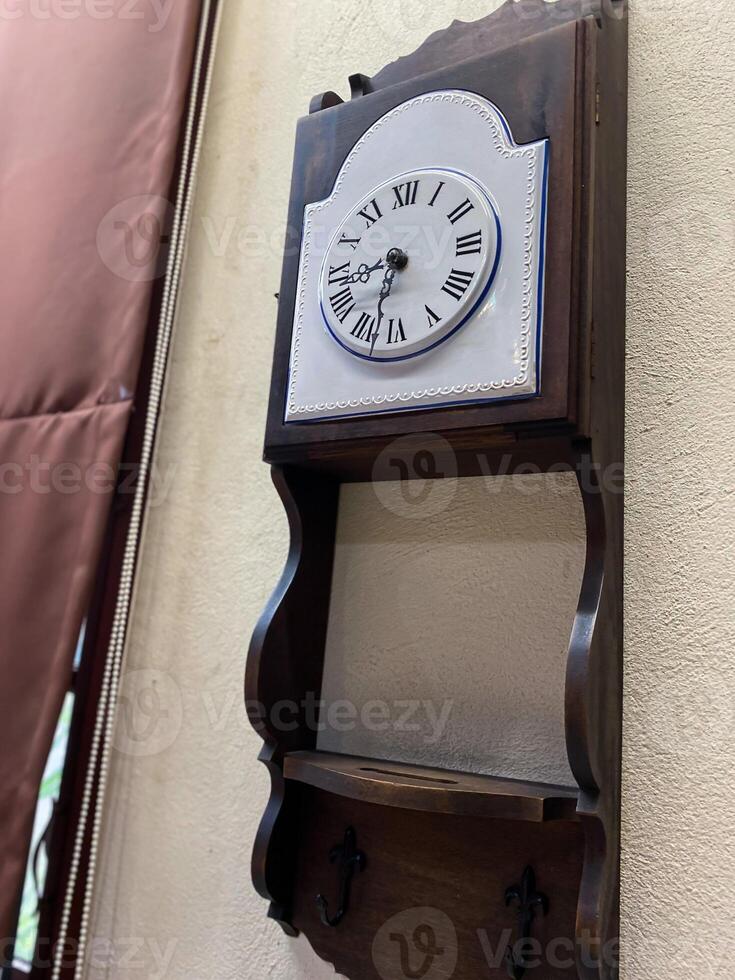 A clock mounted on a wall with a shelf photo