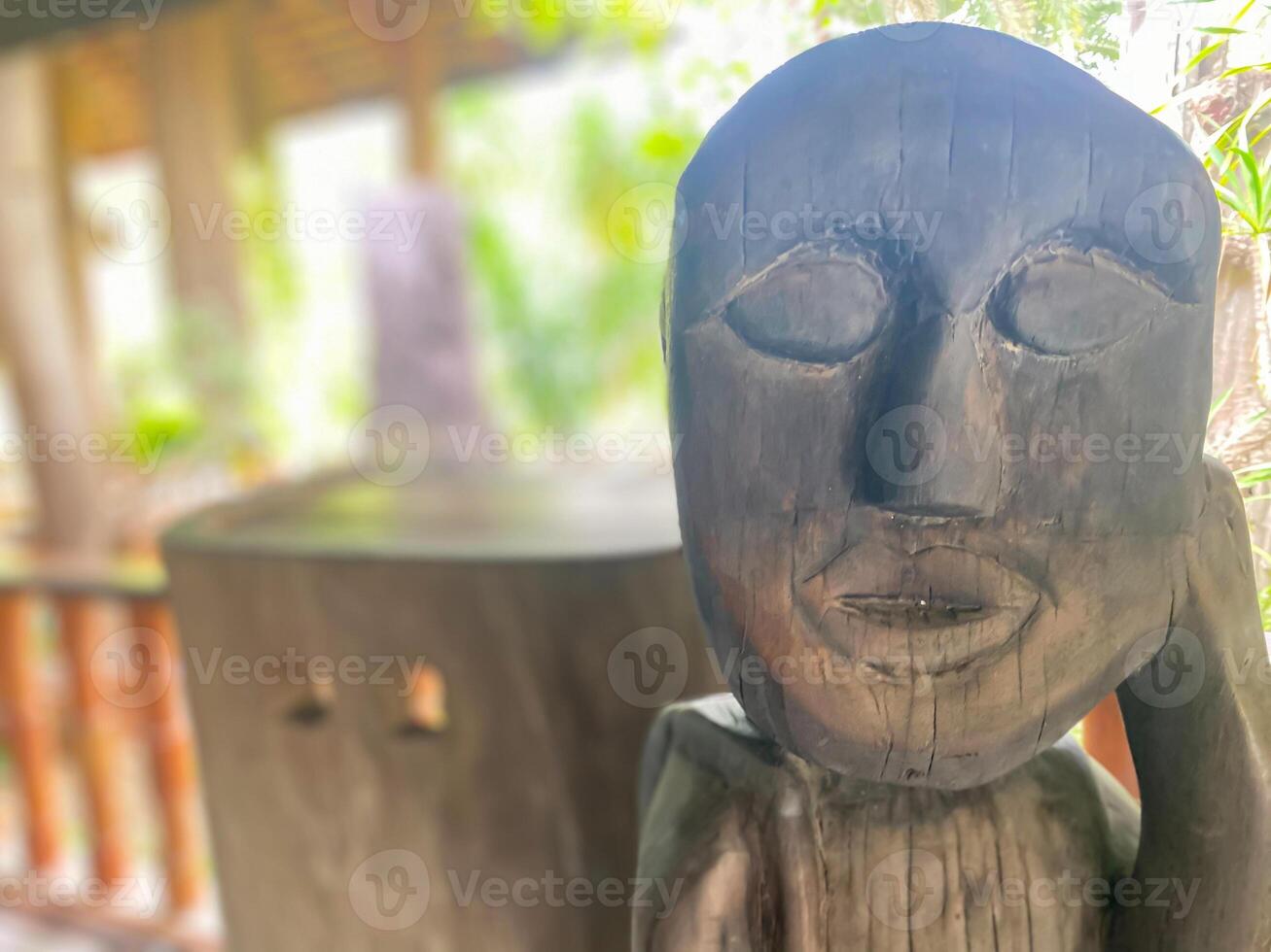 A wooden statue of a man with a face photo