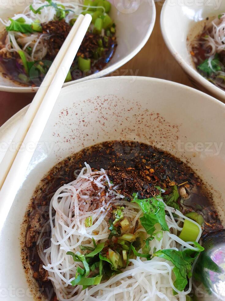 A bowl of soup with noodles and vegetables photo