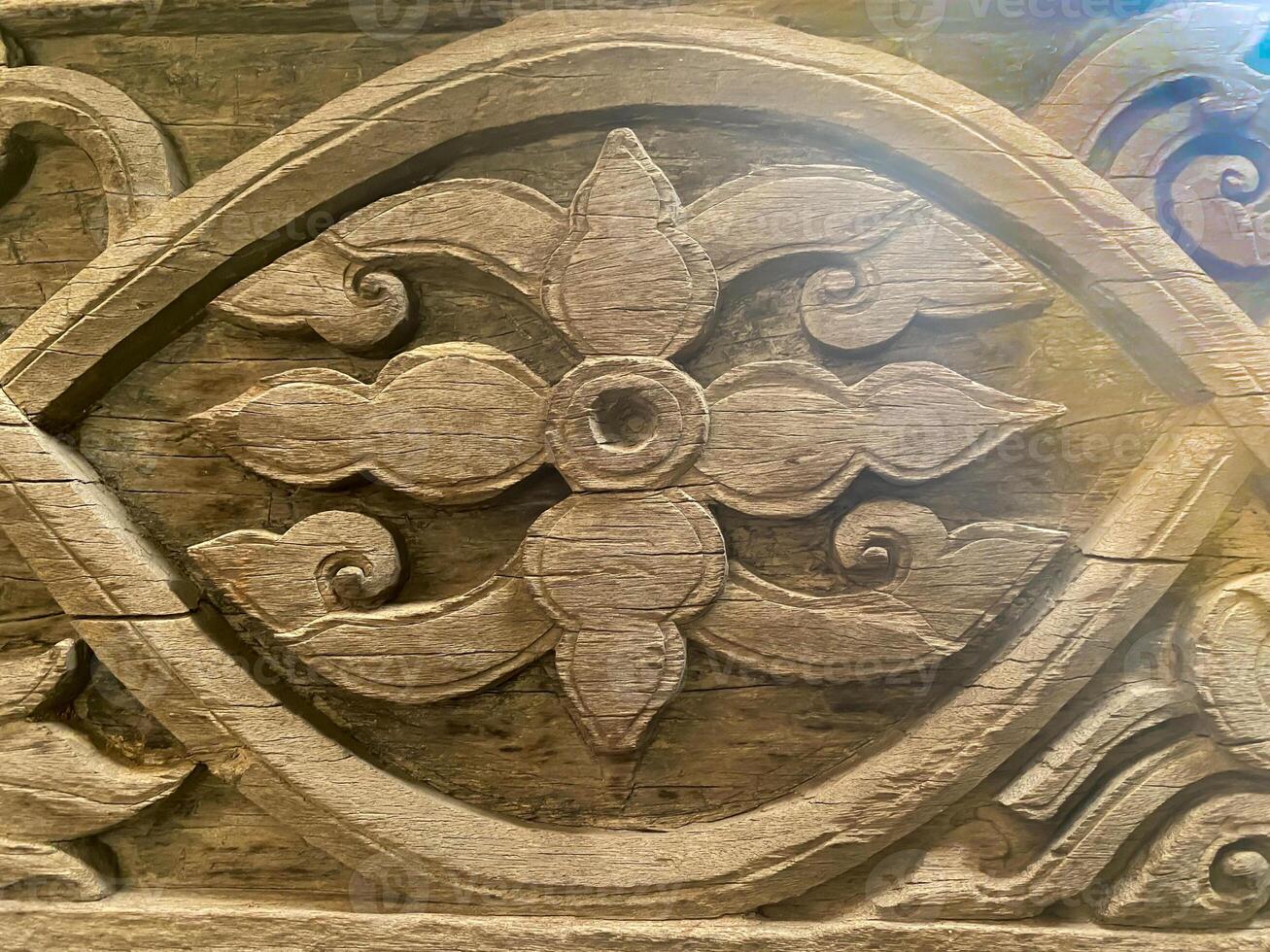 A carved wooden panel with a flower design photo