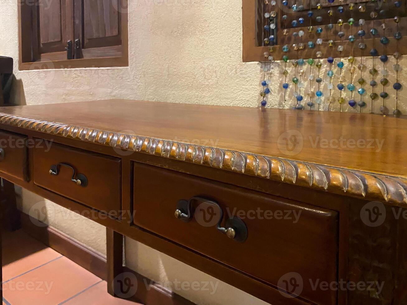 A wooden desk with drawers and a window photo