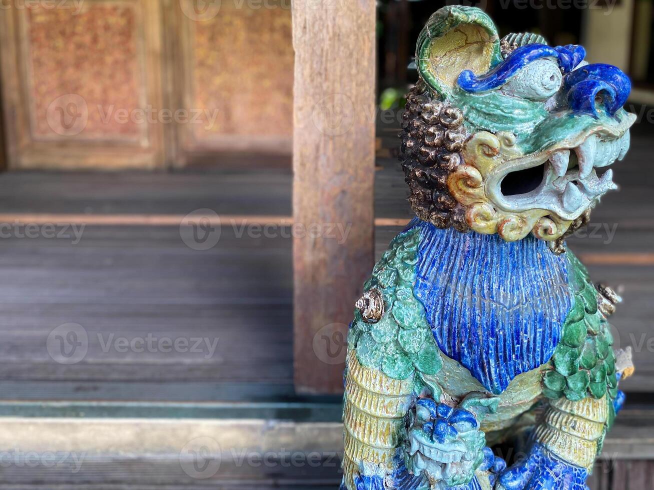 A statue of a lion with a blue and green design photo
