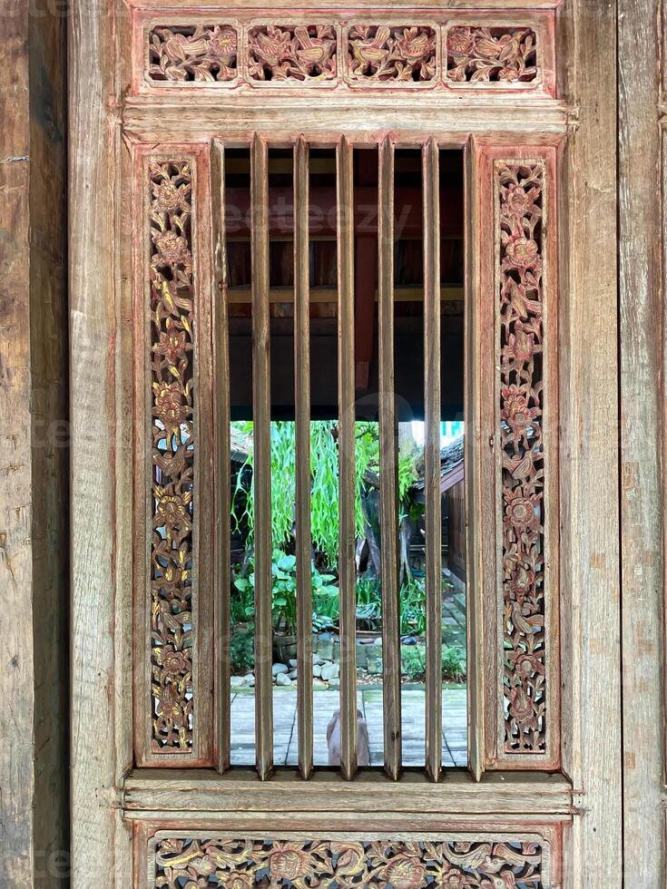 An old wooden door with a window and a wooden frame photo