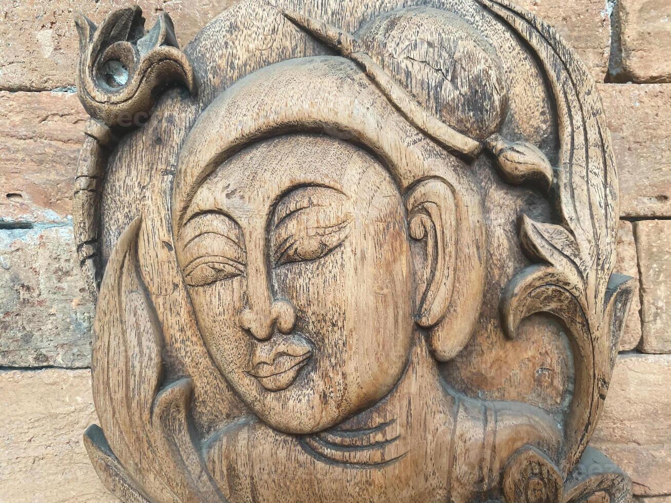 A wooden carving of a buddha head photo
