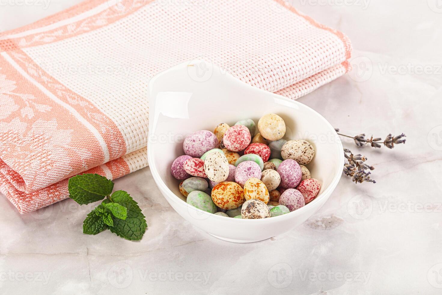 A bowl of colorful candy and a towel photo