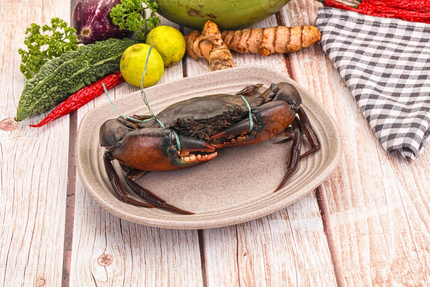A plate with a crab on it next to other vegetables photo