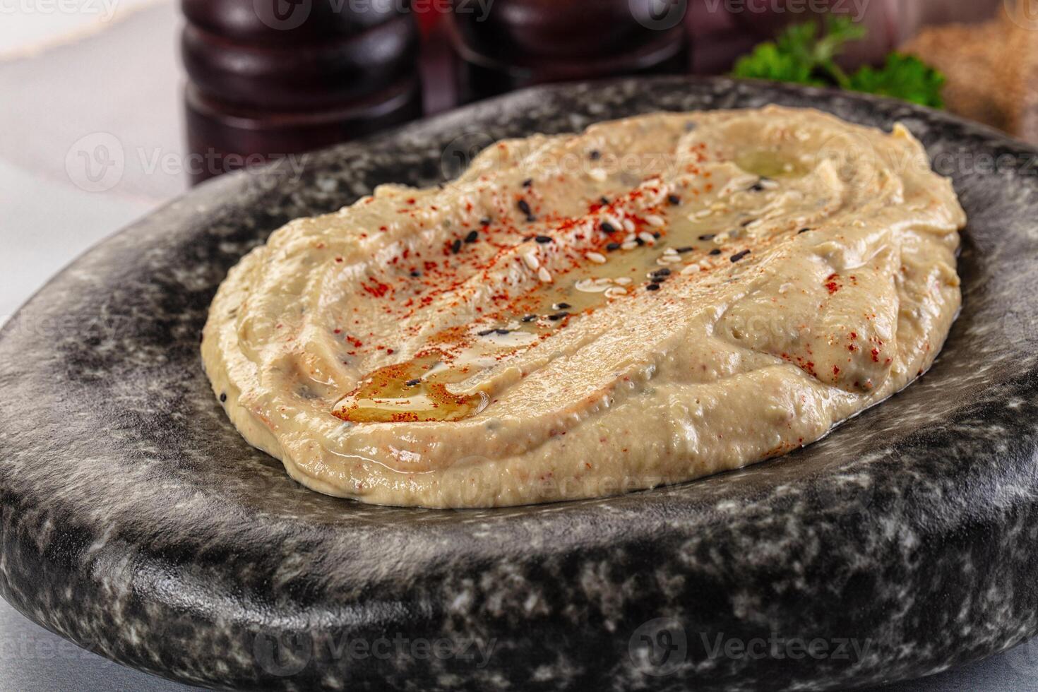 A bowl of hummus with a spoon on top photo