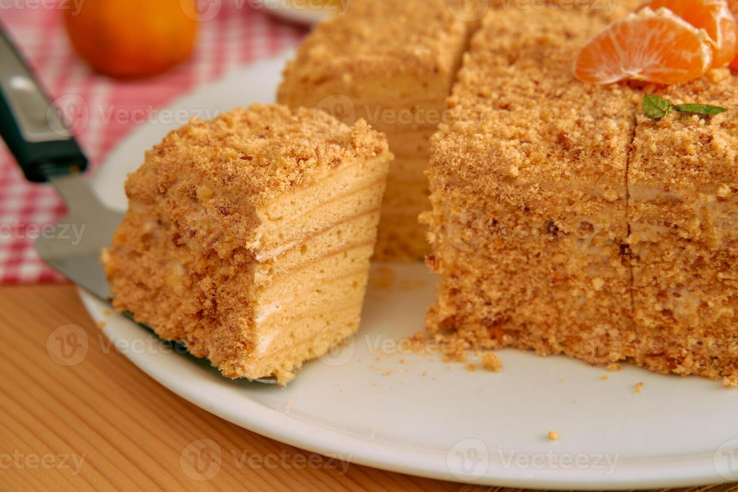 Delicious honey cake with crumbly layers and mandarin garnish photo