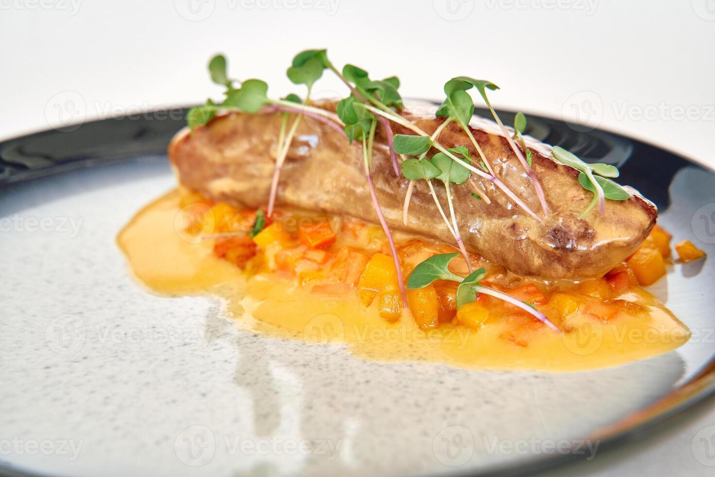 Gourmet seared fish dish with microgreens and citrus sauce on elegant plate photo